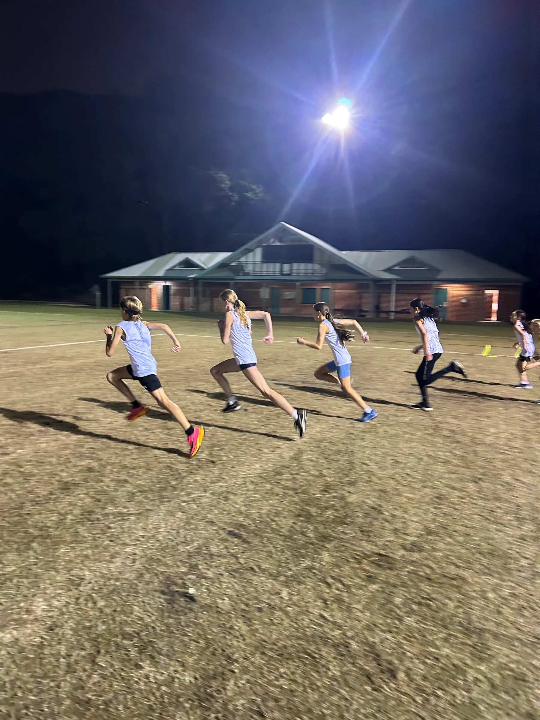 Young athletes doing sprint training under lights